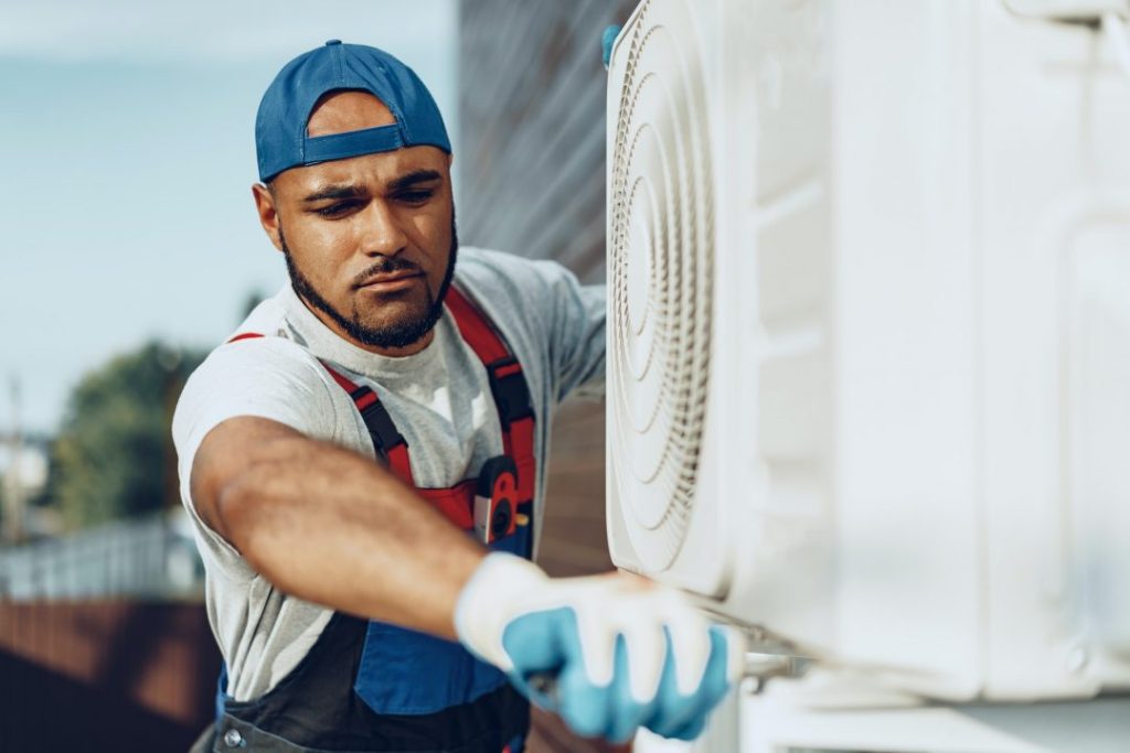 Hawaii AC & Refrigeration technician servicing an outdoor air conditioning unit